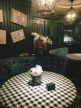 round table in a restaurant in vintage style with flowersの写真素材