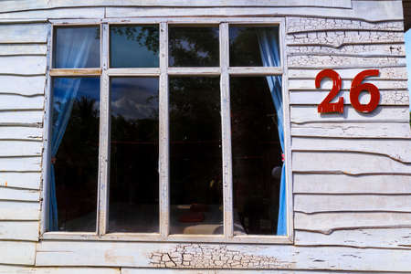 The windows have white wooden walls. House number redの写真素材