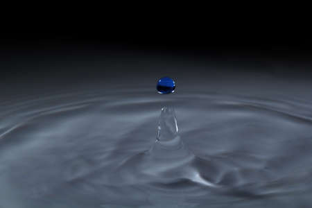 Blue water droplets have a dark background.の写真素材