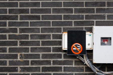 No smoking sign on the wall. No smoking warning sign on electricity meter.