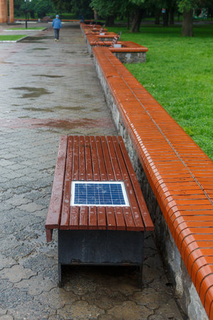A bench with a built-in solar panel for charging phones.の写真素材