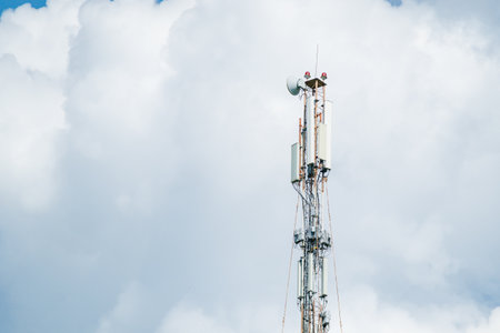 Telecommunication tower of 4G and 5G cellular. Macro Base Station. 5G radio network telecommunication equipment with radio modules and smart antennas mounted on a metal against clouds sky backgroundの写真素材