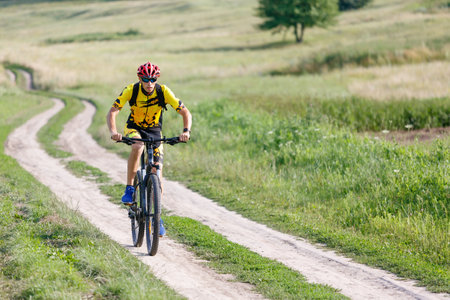 A cyclist in sportswear rides a mountain bike.の写真素材