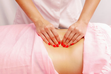 Young woman getting a massage at the spa. A woman enjoys a relaxing back massage in a beauty spa. Body care, skin care.の写真素材
