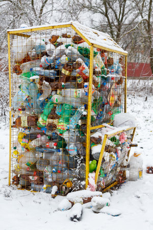 Ukraine, city of Romny, December 26, 2022: Plastic bottles in a trash can, waste management concept. A container for plastic bottles on a winter snowy street. Waste recycling conceptの写真素材