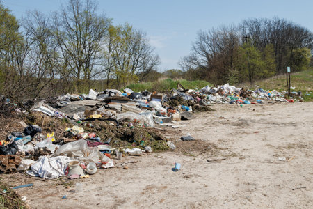 A view of the landfill. Garbage dump. A pile of plastic rubbish, food waste and other rubbish. Pollution concept. A sea of garbage starts to invade and destroy a beautiful countryside scenery.の写真素材