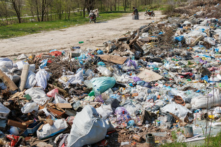 A view of the landfill. Garbage dump. A pile of plastic rubbish, food waste and other rubbish. Pollution concept. A sea of garbage starts to invade and destroy a beautiful countryside scenery.の写真素材