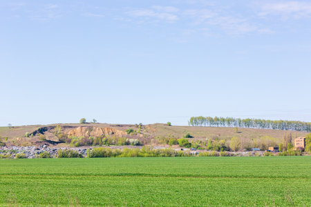 A view of the landfill. Garbage dump. A pile of plastic rubbish, food waste and other rubbish. Pollution concept. A sea of garbage starts to invade and destroy a beautiful countryside scenery.の写真素材