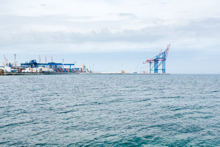 A cargo seaport full of containers. Loading and unloading of cargo. Port cranes.