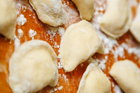 Close-up of handmade varenyky on a wooden board, view from above. Cooking dumplings on a wooden boardの写真素材