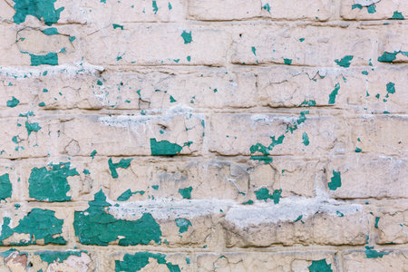 Background of old vintage dirty brick wall with peeling plaster and paintの写真素材