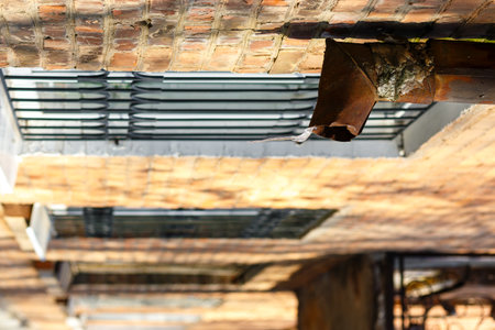 Ice in the downpipe in winter. A rusty downpipe on an old house. A fragment of an old pipe made of...