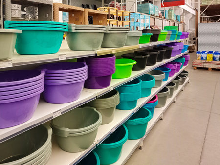 Colorful plastic buckets, basins, and stools neatly arranged on store shelves, showing a variety of household essentials for everyday use.の写真素材