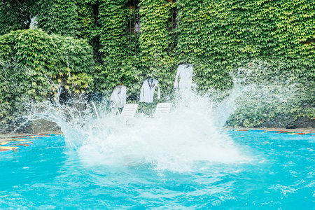 A strong splash of water and lots of splashing after jumping into the water. Water splashes after someone jumps into the poolの写真素材