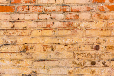 Background of old vintage dirty brick wall with peeling plaster and paintの写真素材