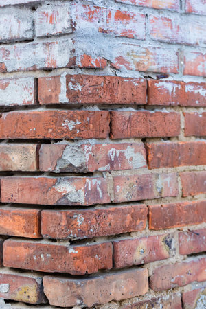 Background of old vintage dirty brick wall with peeling plaster and paintの写真素材