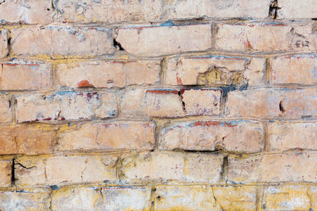 Background of old vintage dirty brick wall with peeling plaster and paintの写真素材
