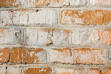 Background of old vintage dirty brick wall with peeling plaster and paintの写真素材