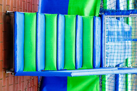 Close-up of vibrant wet foam steps in bright green and blue colors leading to a trampoline. The...