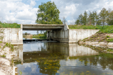Concrete bridge and low-head weir in a managed river system, supporting flood control, erosion prevention, and aquatic habitat restoration.の写真素材