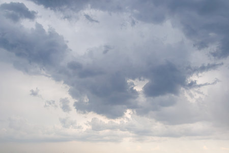 Dark gray clouds filling the sky, signaling an approaching storm or heavy rain, creating a moody and atmospheric weather scene.の写真素材