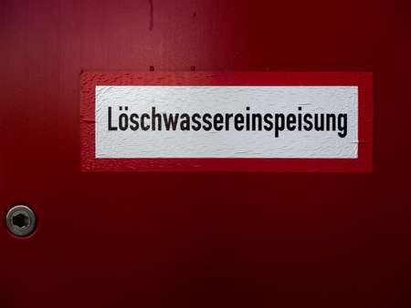 Red lockable cabinet with Hydrant inside for fire fighting in Germany. Loeschwassereinspeisung means extinguishing water supply.の写真素材