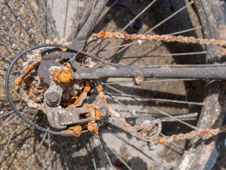 Detail shot of rusty part of  gear change and chain of a bycicle with selective focus from above. Rear part of gear change.の写真素材