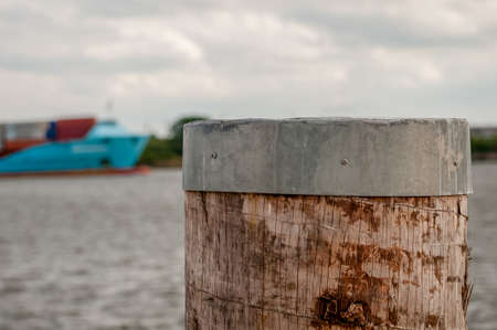 Close-up of dolphin and container vessel in blurry background at day. in Hamburg harbor. Selective...