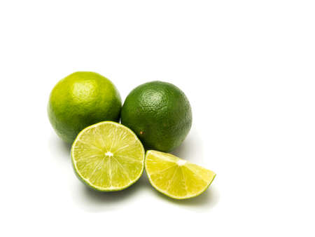 Two limes and in different green tones and two peaces with visible flesh isolated on white...