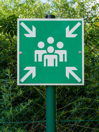 Sign with pictogram symbolizing an assembly station for people in case of an emergency or...