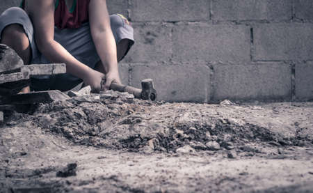 World Day Against Child Labour concept: Poor little boy working at construction site