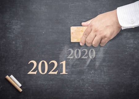 Businessman hand holding eraser for change word "2020" to "2021"の写真素材