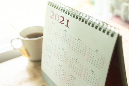 Paper calendar 2021 schedule with tea cup on wooden deskの写真素材