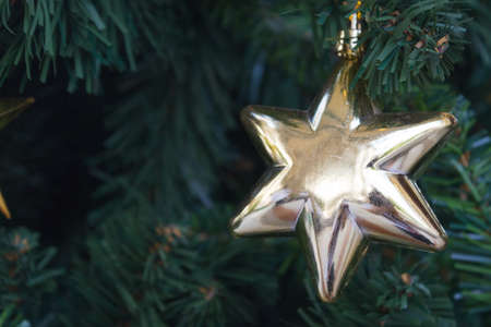 golden christmas star hanging on the christmas tree 