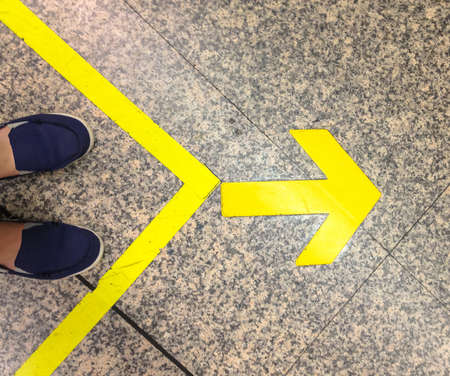 Man standing behind direction signs  to right wayの写真素材