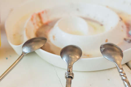 Empty dirty plate at the end of a break meal with spoonの写真素材