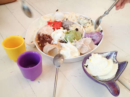 eating ice cream scoops in a dish with spoon;