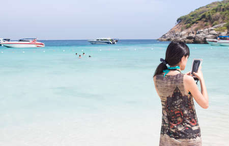 back of happiness traveler take a photo sea sunsetの写真素材