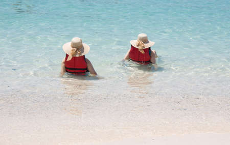 back of happiness lover couple play at blue sea beach togetherの写真素材