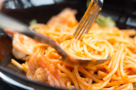 close up tasty tomato-sauce spaghetti with forkの写真素材