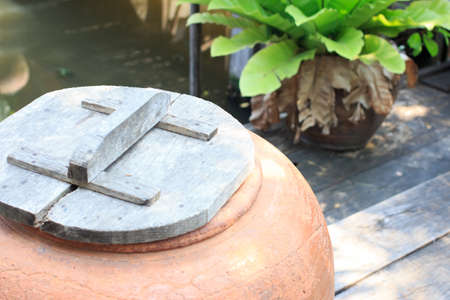 aged water earthen jar in the gardenの写真素材
