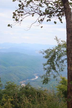 riverside in center of green mountain with forest backgroundの写真素材