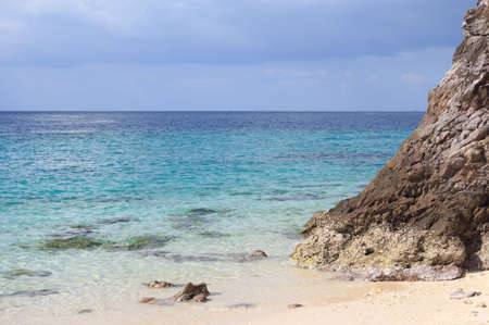 clear water sea and rough rock stone at Tropical white bay beach with sunset nature composition