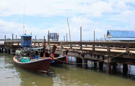 long tail fishing boat with goods in dock pier sea Trang, Thailandの写真素材