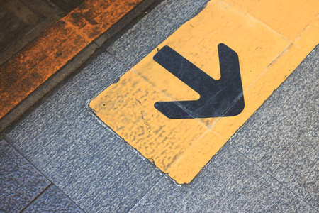 yellow arrow direction sign on asphalt ,opportunity choice for turn backの写真素材