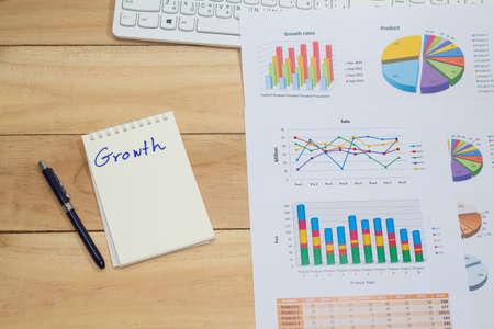 growth rate of Sale analysis report show success result as charts and graphs on document paperwork,with blank space wooden table backgroundの写真素材