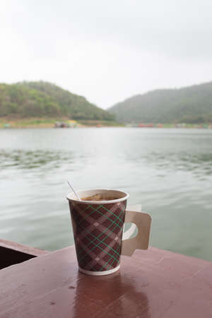 brown and hot coffee cup in morning with river viewの写真素材