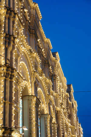 The building is lit at night with garlands and lights.の写真素材