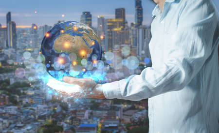 Businessman holding the Earth in his hand [Elements of this image furnished by NASA]の写真素材