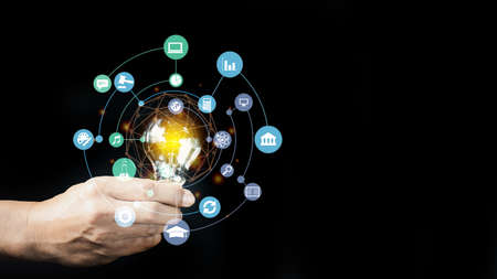 Hand holding light bulb with digital business interface. Global business and media concept.の写真素材